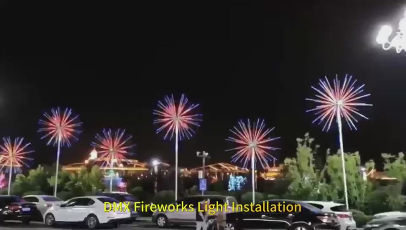Nighttime installation of giant RGB DMX-controlled LED fireworks lights illuminating in red and blue patterns, part of a dynamic outdoor lighting display